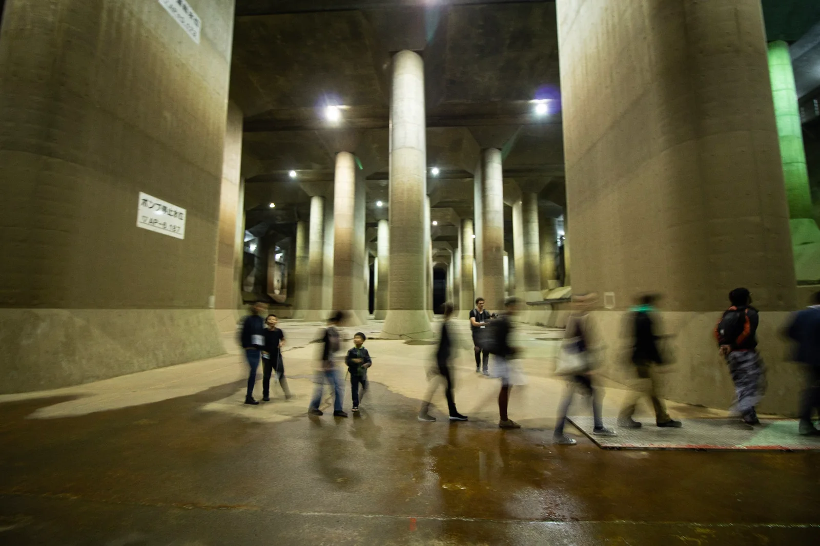Visitors beneath the concrete pillars of the G-Cans surge tank during a 2018 tour