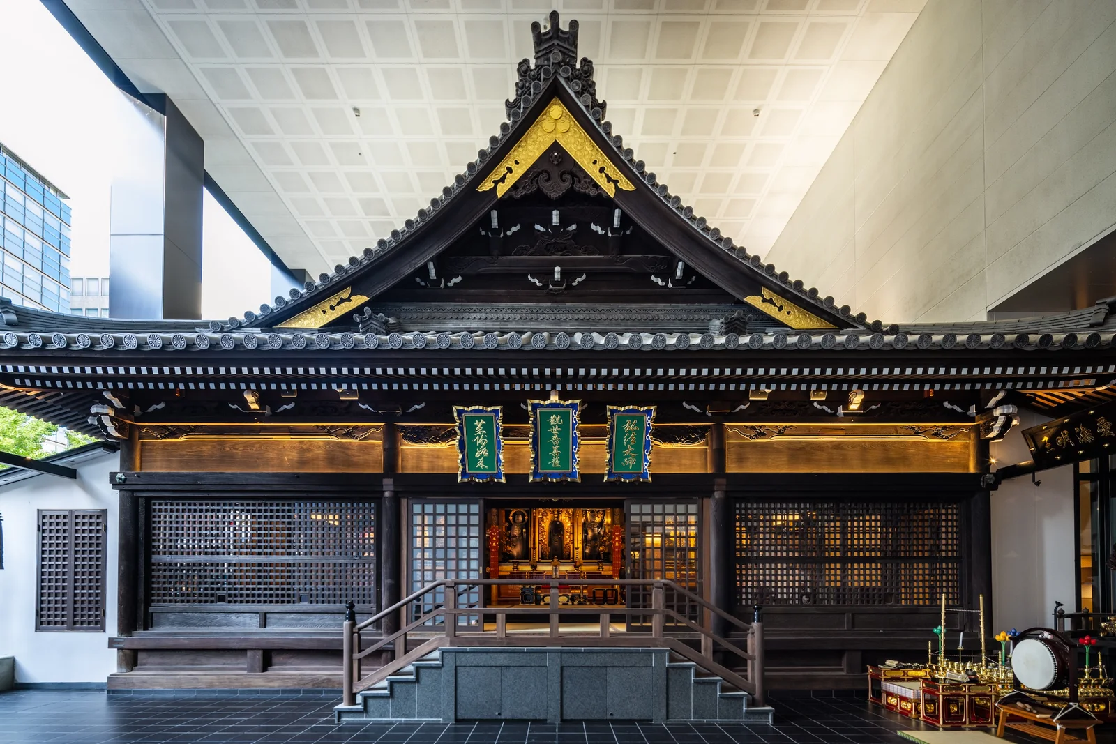 Mitsutera's wooden main hall and tiled roof beneath the ceiling of the modern building